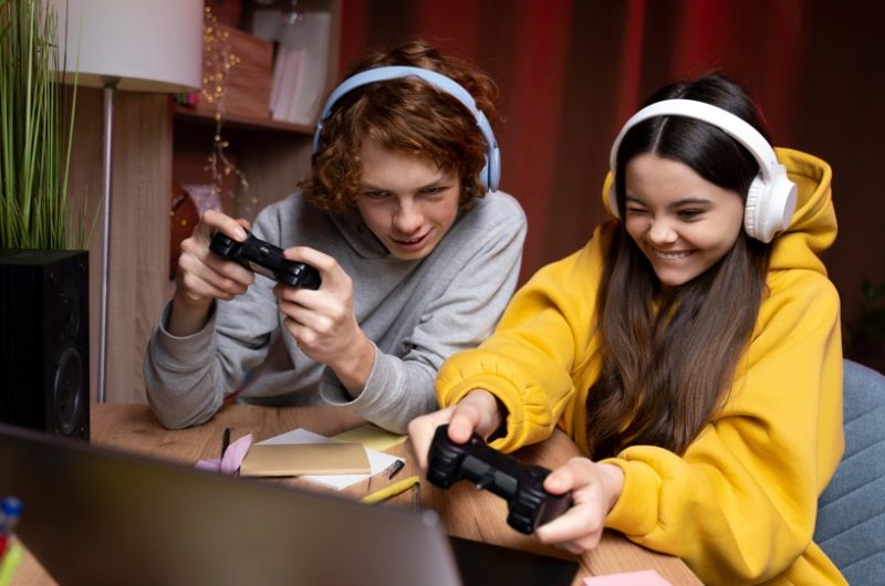 deux-amis-adolescents-jouant-jeux-video-ensemble-maison freepik
